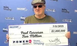 男子误买两张相同彩票揽1434万 戴墨镜领奖-图